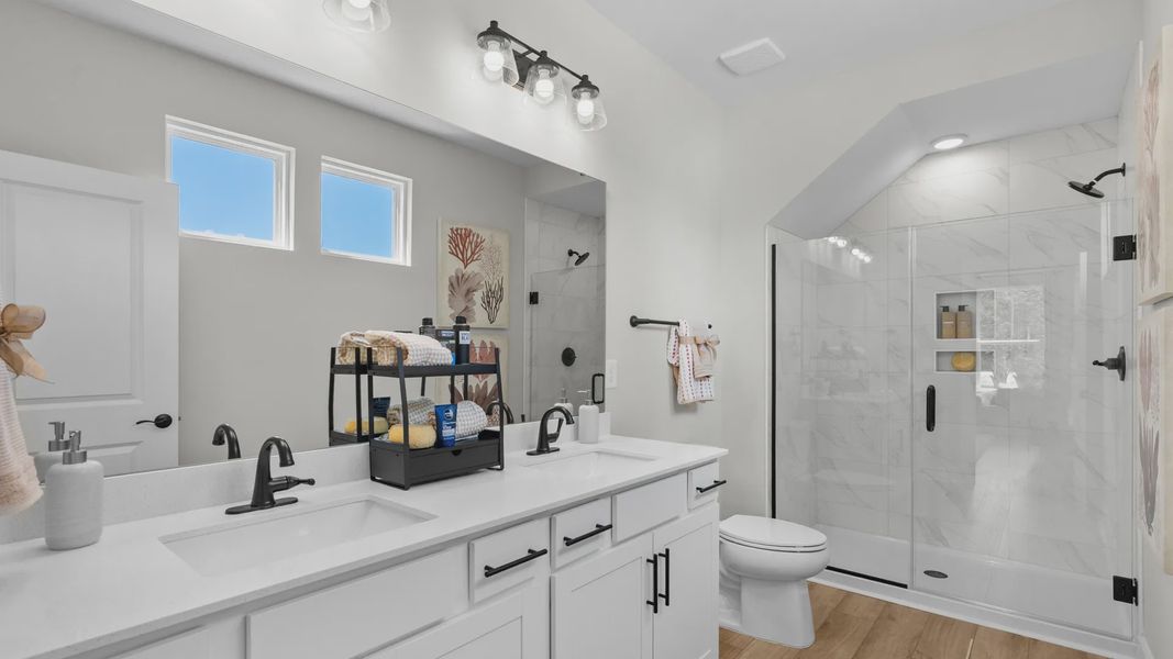 Primary bathroom in the Summit home plan with modern finishes and dual vanities.