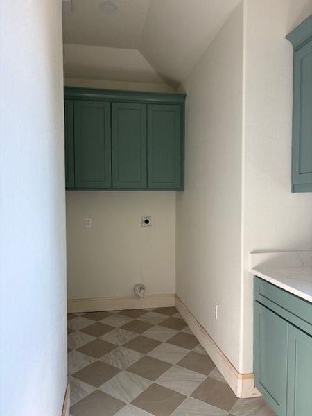 Washroom featuring cabinet space, light floors, lofted ceiling, and electric dryer hookup
