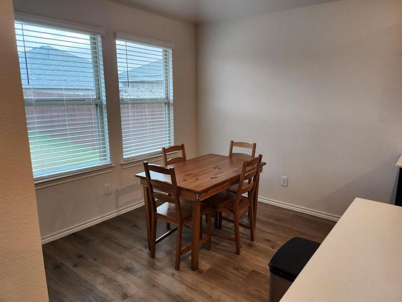 Dining area with dark wood-style flooring