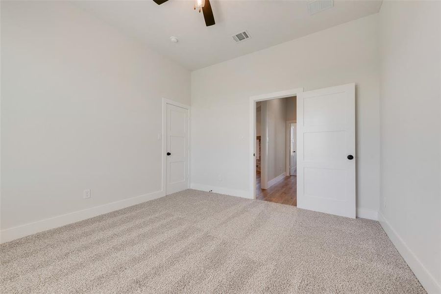 Spacious room featuring vaulted ceilings, light neutral wall tones, and plush carpet flooring