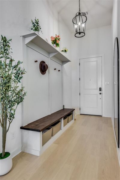 An inviting entrance foyer welcomes guests with sleek wood flooring and a built-in drop zone. An inviting entrance foyer welcomes guests with sleek wood flooring and a built-in drop zone.