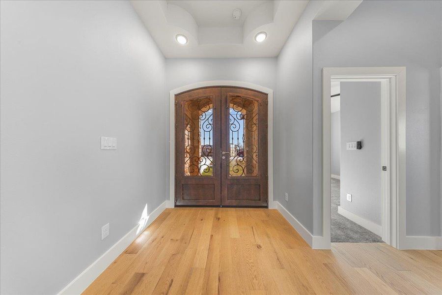 Foyer entrance featuring light wood-type flooring and french doors Foyer entrance featuring light wood-type flooring and french doors