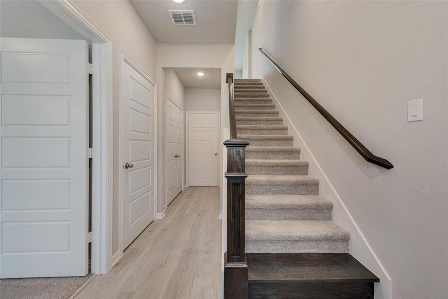 Staircase with light hardwood / wood-style floors