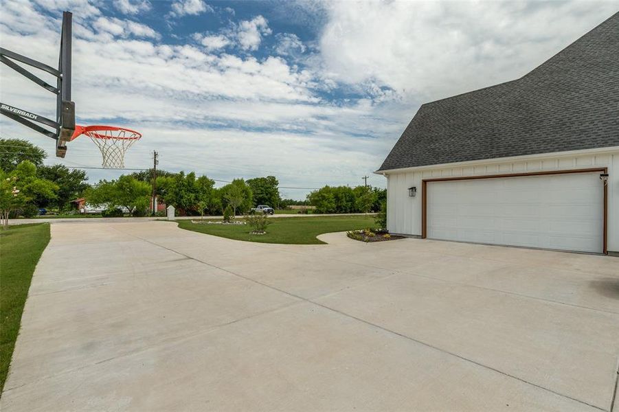 Long concrete driveway with basketball hoop and side garage Long concrete driveway with basketball hoop and side garage