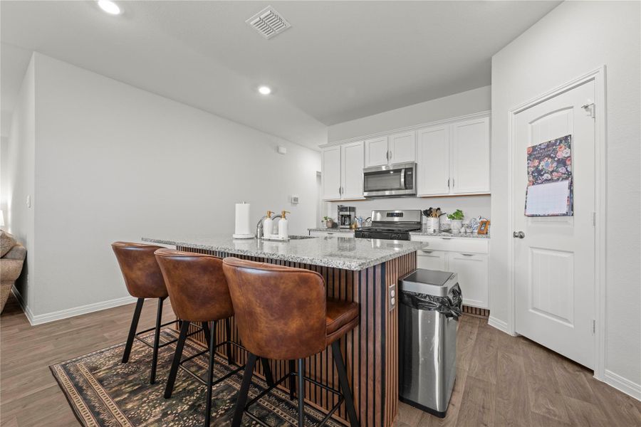 A well-appointed kitchen features a central island with bar seating and sleek stainless steel appliances.