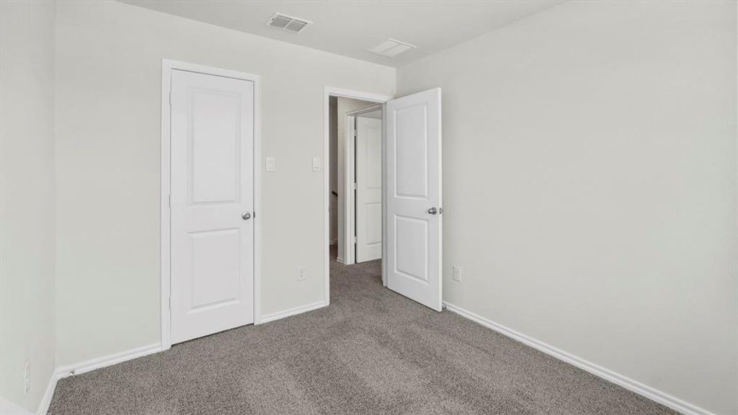 This room features light grey walls, grey carpet flooring, and white trim
