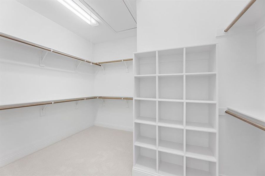 Walk in closet with light colored carpet and attic access Walk in closet with light colored carpet and attic access