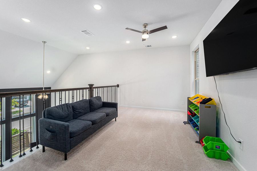 Versatile upstairs loft perfect for a playroom, media space, or home office.