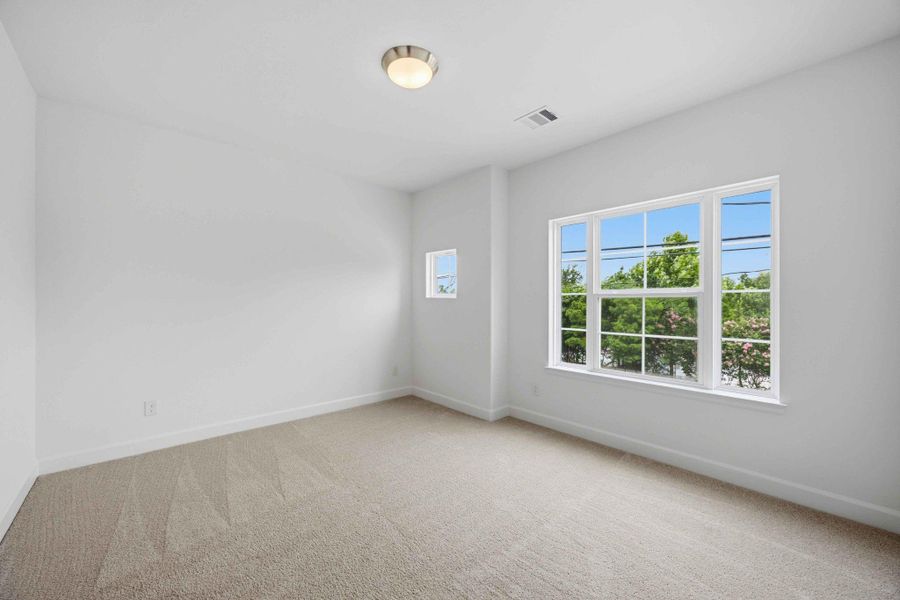 Light and spacious, this larger secondary bedroom at the front of the house shines.