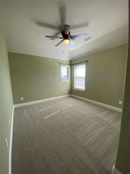 Unfurnished room featuring vaulted ceiling, carpet, and a ceiling fan Unfurnished room featuring vaulted ceiling, carpet, and a ceiling fan