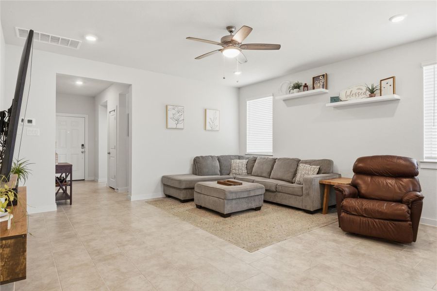 Living room featuring a ceiling fan and recessed lighting