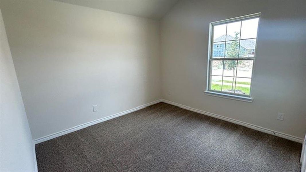 Neutral wall paint, plush carpet, and a large window with exterior views