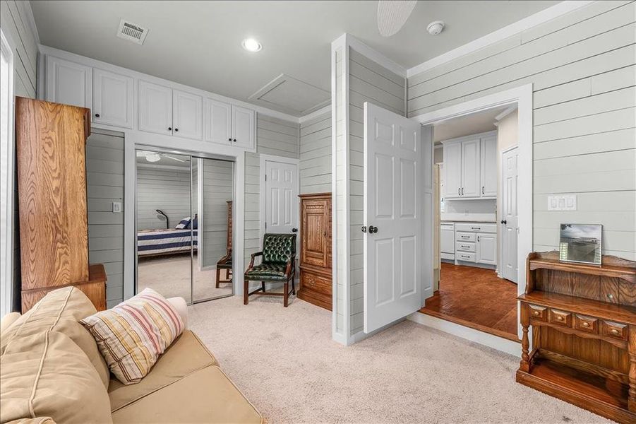 Living area with wooden walls, light carpet, and recessed lighting