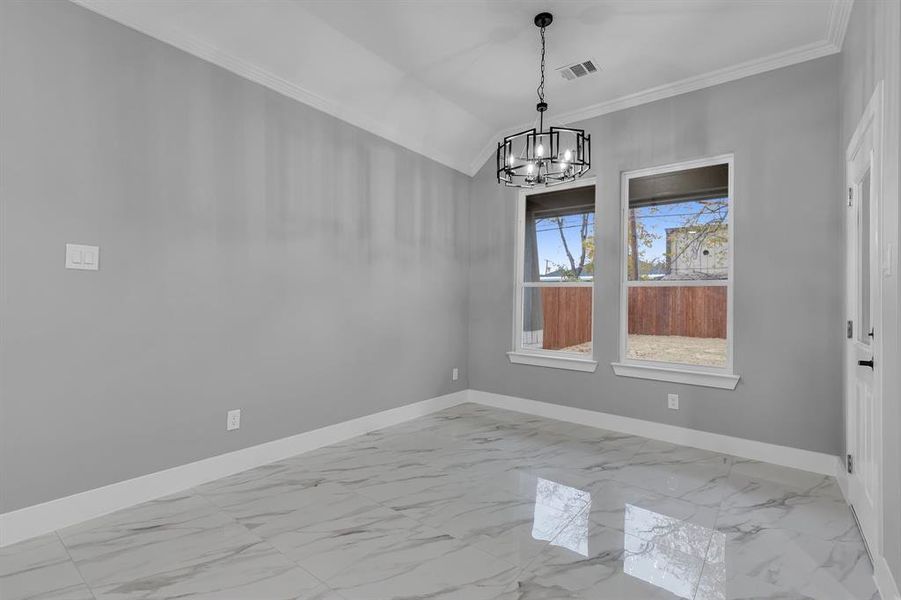 Unfurnished dining area with a notable chandelier, lofted ceiling, and crown molding