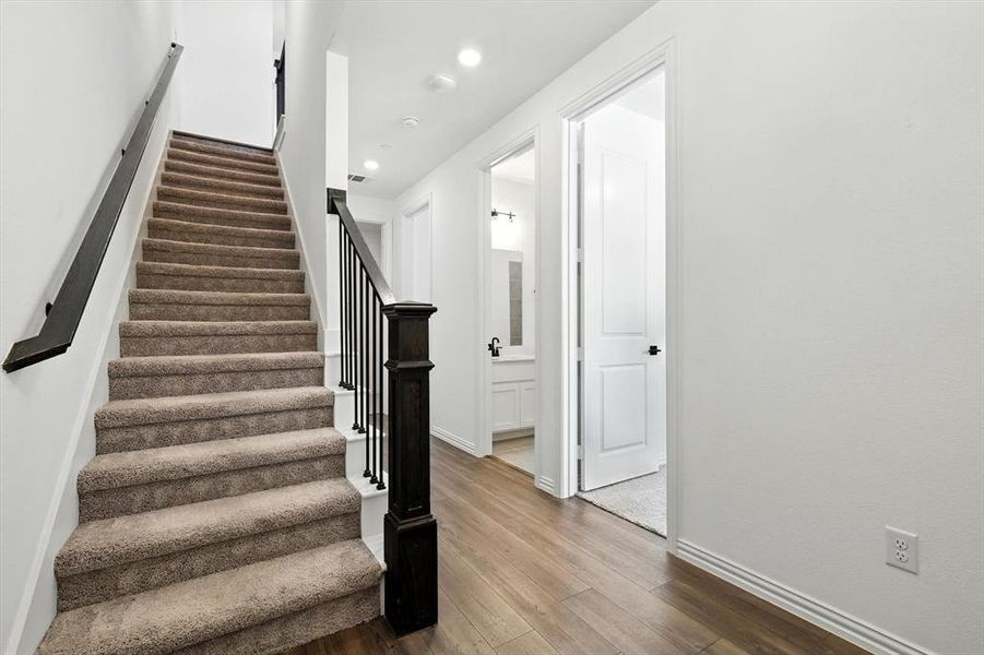 Stairway with handrail on entry leading to 2nd floor.  2 bedroooms and a full bath plus laundry room  to the right.