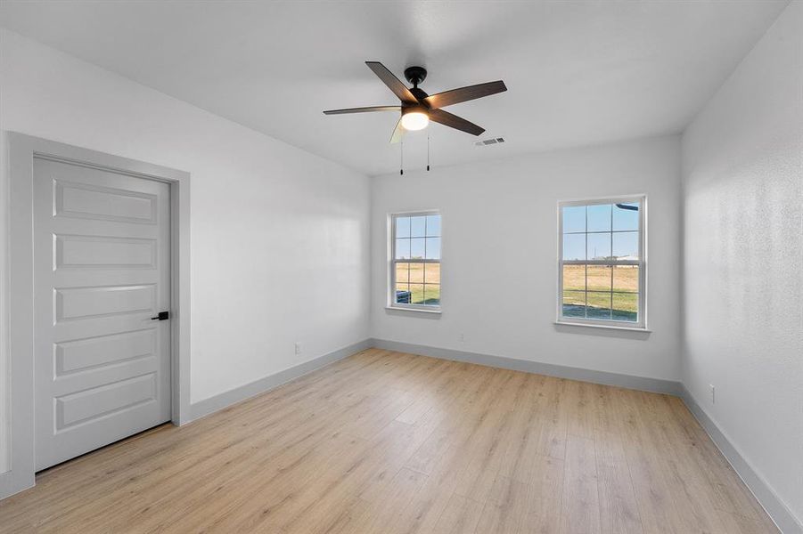 Empty room featuring light wood-style flooring and a ceiling fan