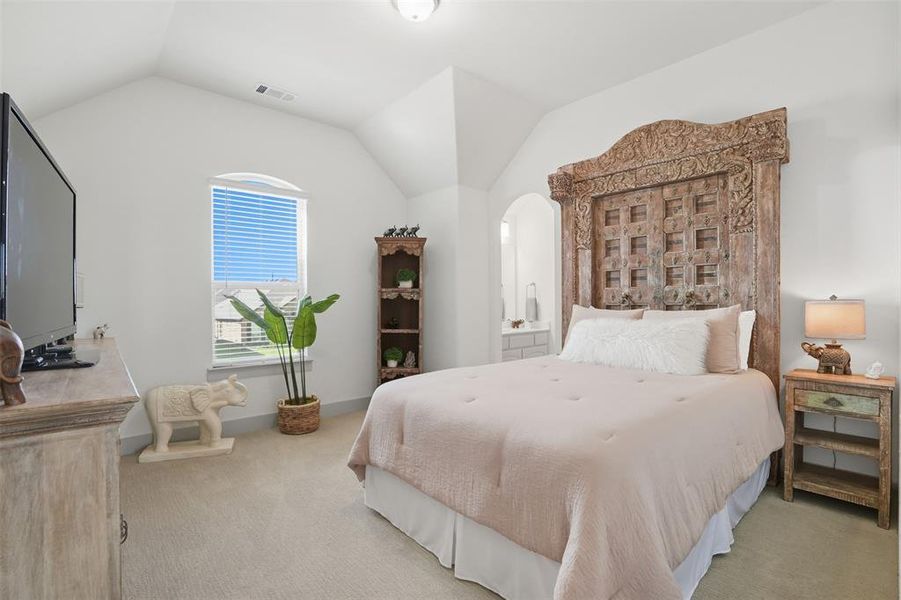 Bedroom featuring light colored carpet and vaulted ceiling Bedroom featuring light colored carpet and vaulted ceiling