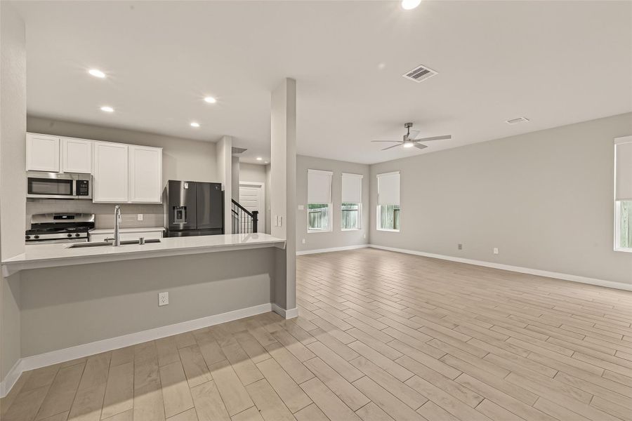 A view from the dining area shows the kitchen and living room, highlighting the open layout and easy flow between the spaces.