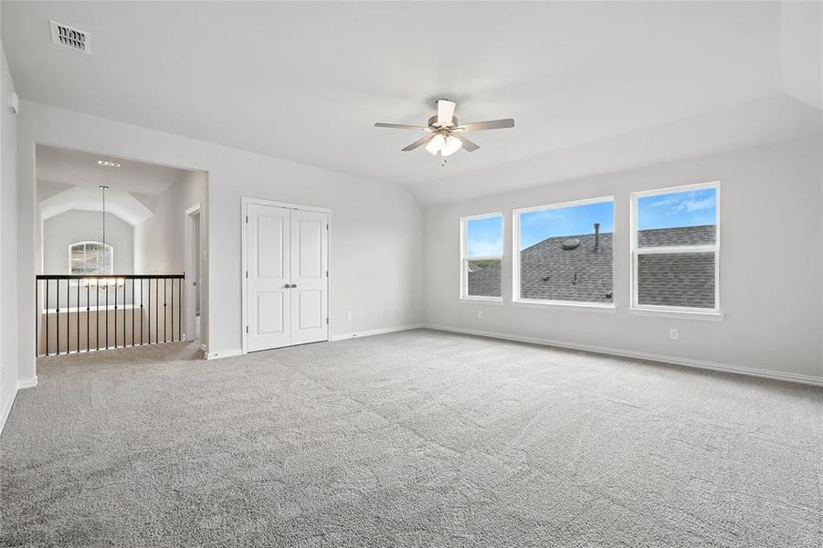 Carpeted spare room featuring a ceiling fan and baseboards Carpeted spare room featuring a ceiling fan and baseboards