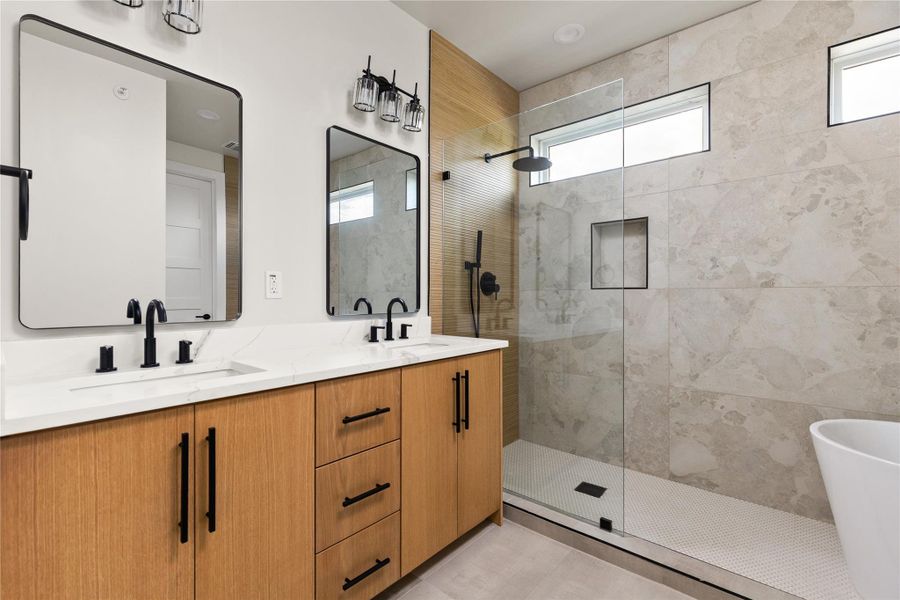 A contemporary primary bath showcases a double vanity, large walk-in shower, and freestanding tub.