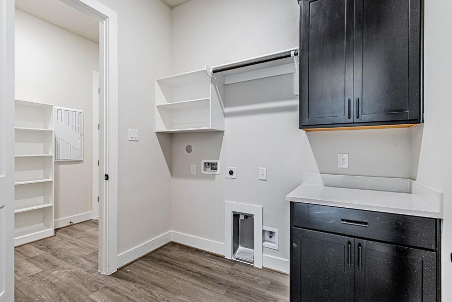 Laundry room with built-in cabinetry and utility sink area Laundry room with built-in cabinetry and utility sink area
