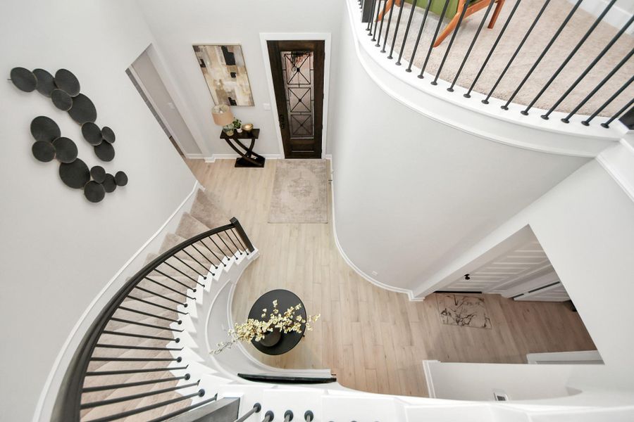 Elegant entry—arched stair, statement front door, and gallery wall niche.