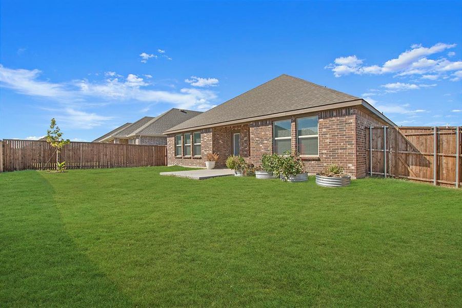 Rear view of property featuring a patio area and a lawn