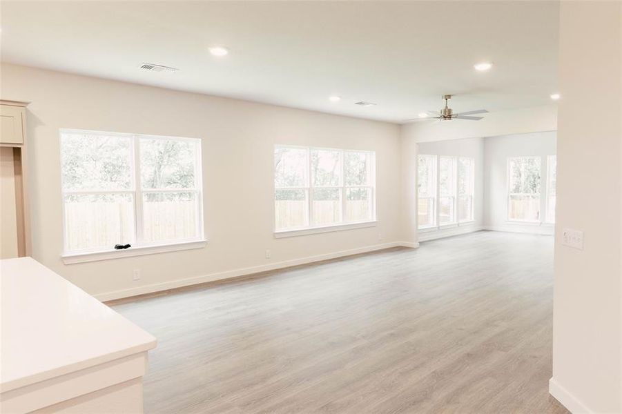 Unfurnished living room with ceiling fan and light hardwood / wood-style flooring