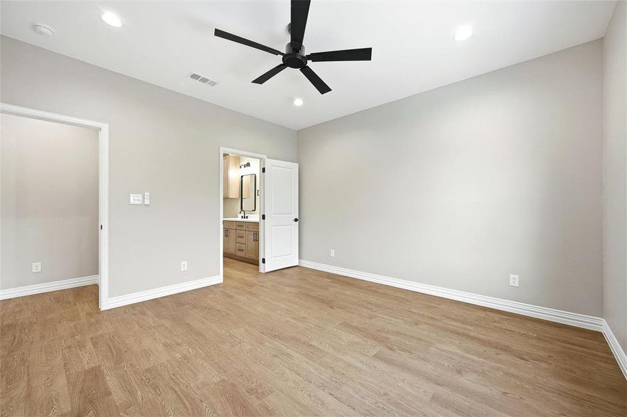 Unfurnished bedroom featuring ceiling fan, recessed lighting, light wood finished floors, and connected bathroom Unfurnished bedroom featuring ceiling fan, recessed lighting, light wood finished floors, and connected bathroom