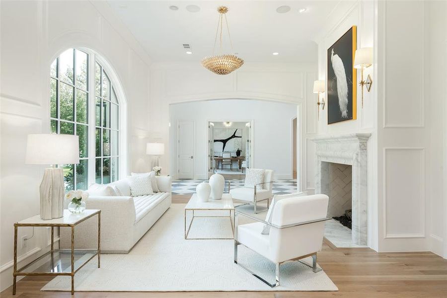 Living room with a fireplace, light hardwood / wood-style flooring, and ornamental molding