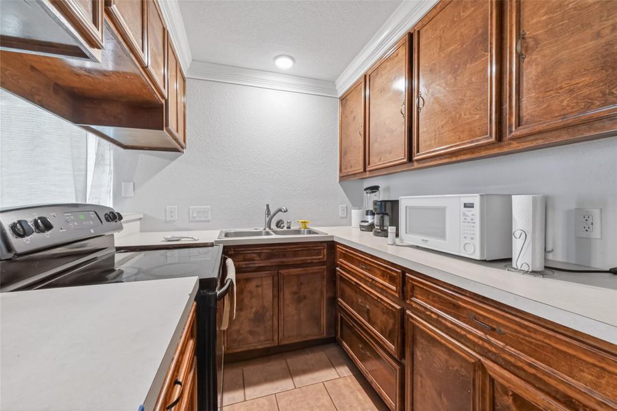 Alternate view of the second-level kitchen with wood cabinetry, ample prep space, and bright finishes.