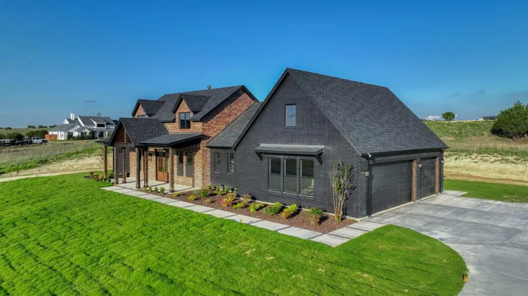 Contemporary exterior featuring dark brick, a covered porch with timber columns, and a concrete driveway Contemporary exterior featuring dark brick, a covered porch with timber columns, and a concrete driveway