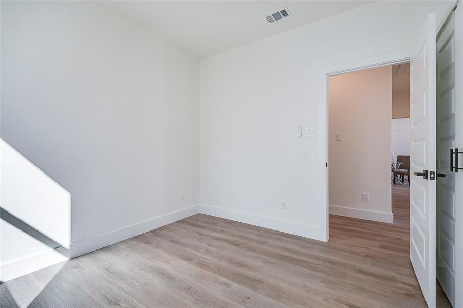 Empty room with light hardwood / wood-style floors