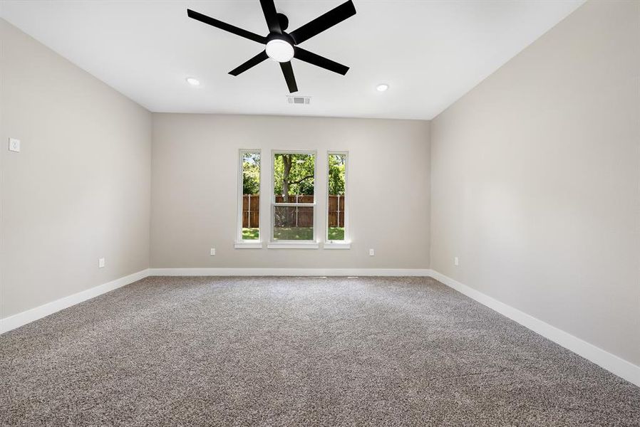 Primary bedroom view from bathroom door featuring ceiling fan, carpet, and recessed lighting Primary bedroom view from bathroom door featuring ceiling fan, carpet, and recessed lighting