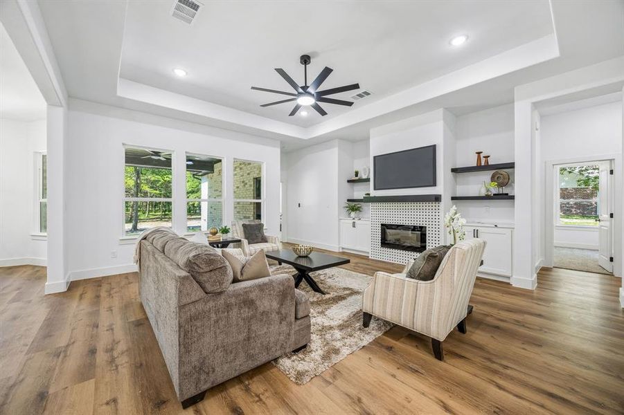 Open-concept living space featuring a modern electric fireplace with white patterned tile surround, recessed lighting and a contemporary ceiling fan