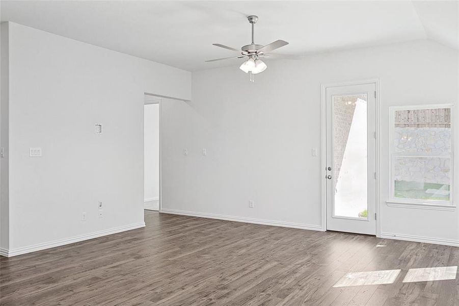 Unfurnished living room featuring lofted ceiling, ceiling fan, and dark hardwood / wood-style floors