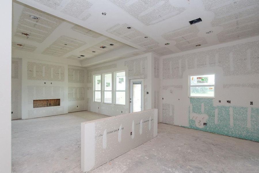 Spacious unfinished open concept showing kitchen island to living space with potential, featuring large windows for natural light and a recessed ceiling design, ready for your custom touches. Spacious unfinished open concept showing kitchen island to living space with potential, featuring large windows for natural light and a recessed ceiling design, ready for your custom touches.