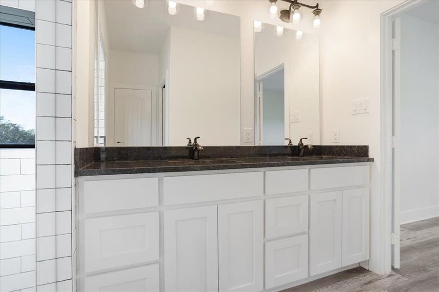 Master bathroom featuring double vanity and wood finished floors