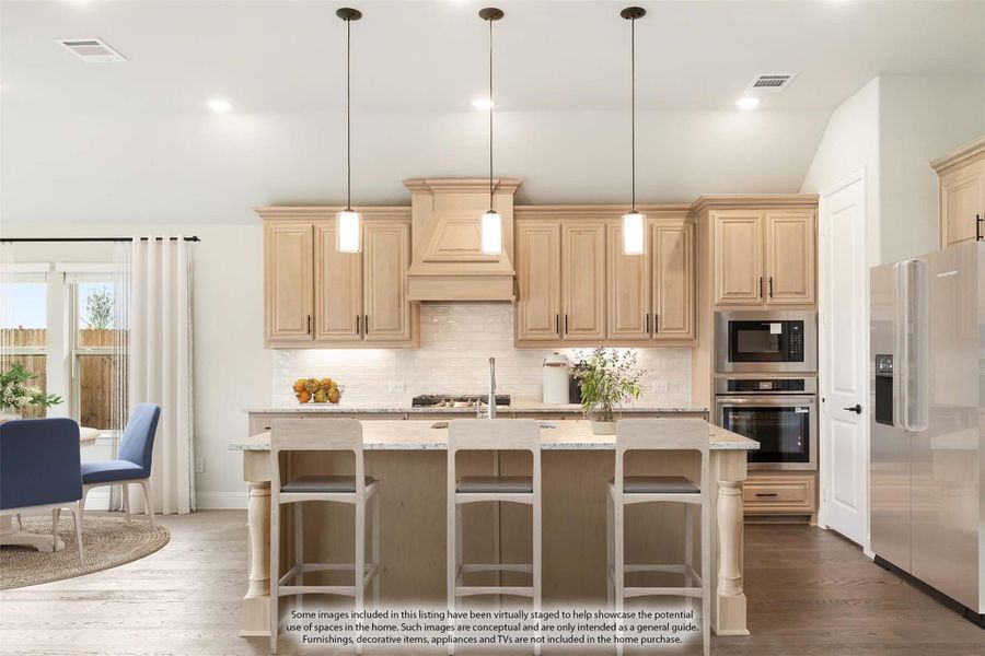 Kitchen with light wood cabinets, large island with seating, pendant lights, and stainless steel appliances Kitchen with light wood cabinets, large island with seating, pendant lights, and stainless steel appliances