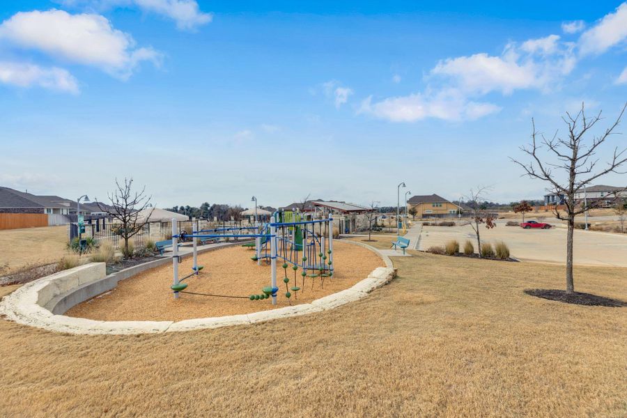 Community play area with a residential view and a lawn