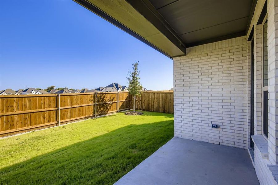 Fenced backyard with a patio area and a residential view Fenced backyard with a patio area and a residential view
