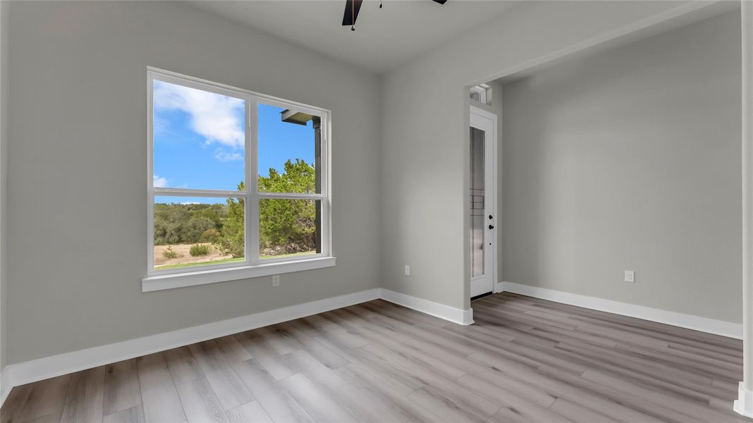 Empty room with ceiling fan and light wood-type flooring