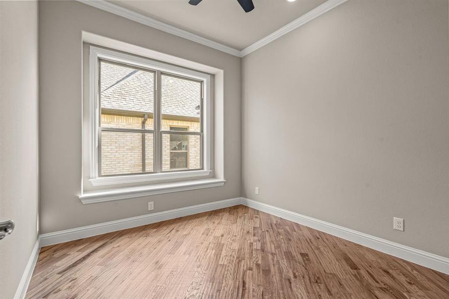 Unfurnished room featuring ornamental molding, light wood-style flooring, and a ceiling fan Unfurnished room featuring ornamental molding, light wood-style flooring, and a ceiling fan