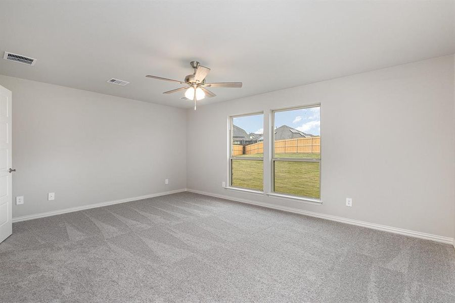 Carpeted spare room with ceiling fan