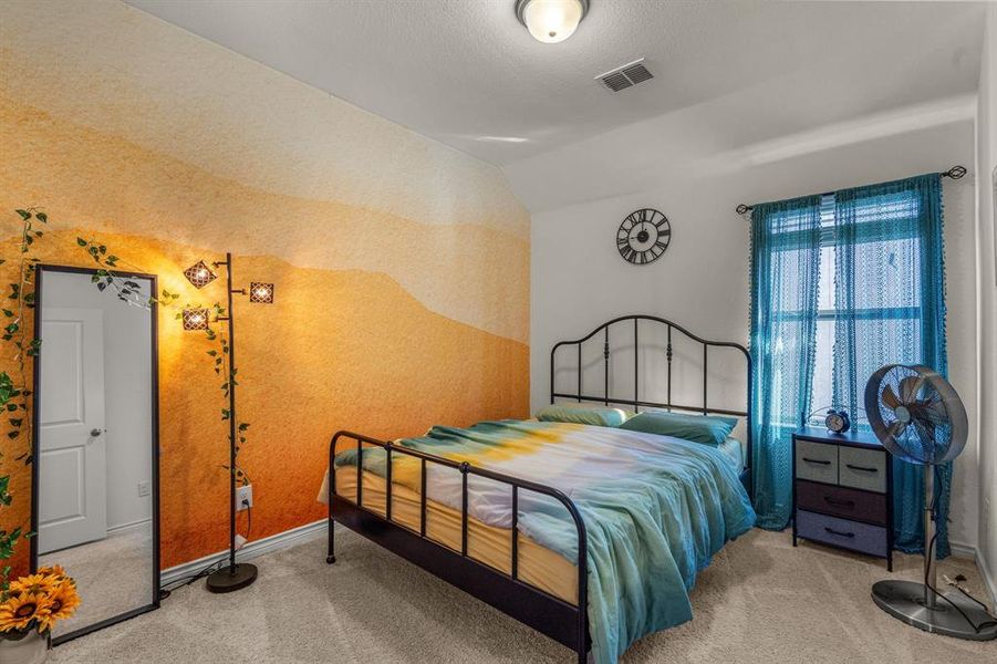 Carpeted bedroom with a textured ceiling and lofted ceiling