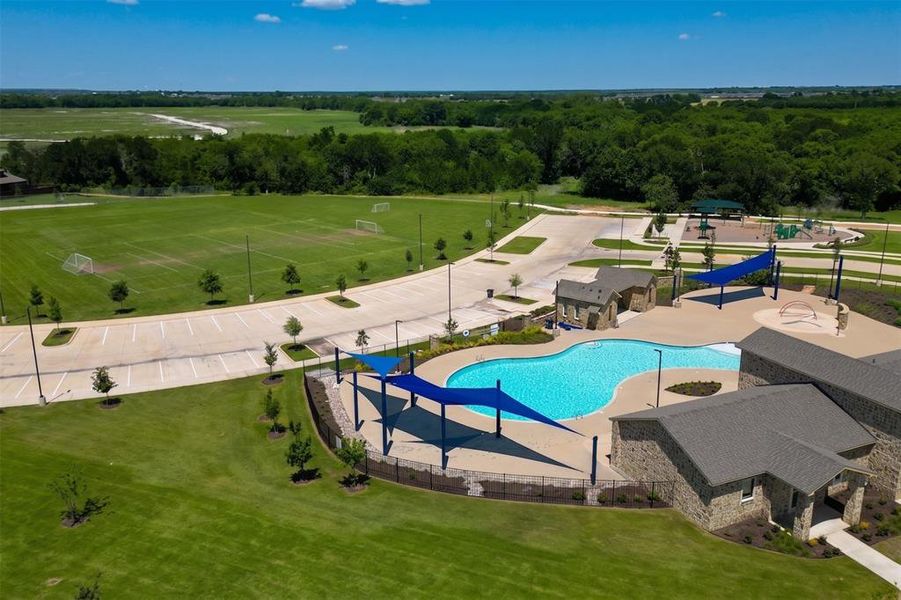 Expansive recreational area featuring a resort-style swimming pool, covered lounge areas, and stone-clad amenity buildings