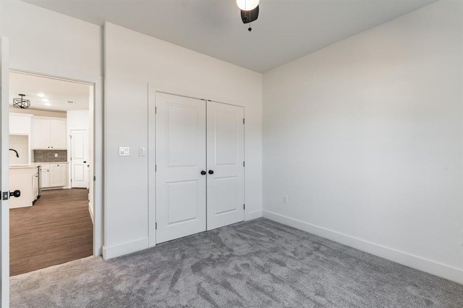 Unfurnished bedroom featuring a closet, sink, and carpet