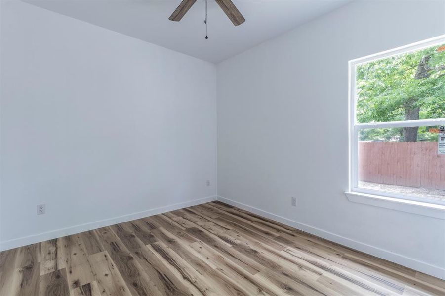 Spare room featuring a ceiling fan, wood finished floors, and baseboards Spare room featuring a ceiling fan, wood finished floors, and baseboards
