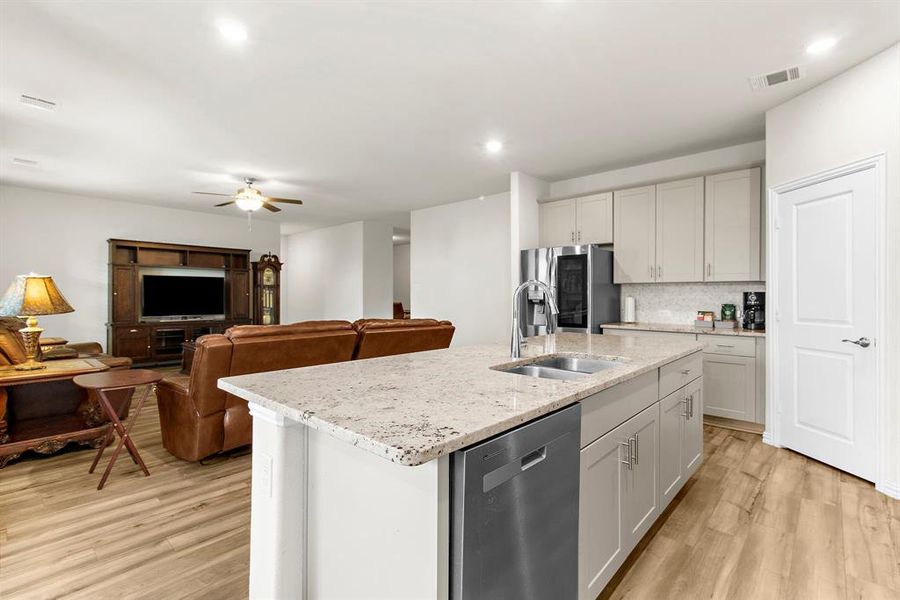 Kitchen featuring stainless steel appliances, light wood-style floors, a ceiling fan, decorative backsplash, and recessed lighting Kitchen featuring stainless steel appliances, light wood-style floors, a ceiling fan, decorative backsplash, and recessed lighting