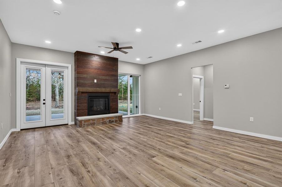 Alternate view of the living area, the double doors open to the covered patio and off to the right is the hall to the primary bedroom.